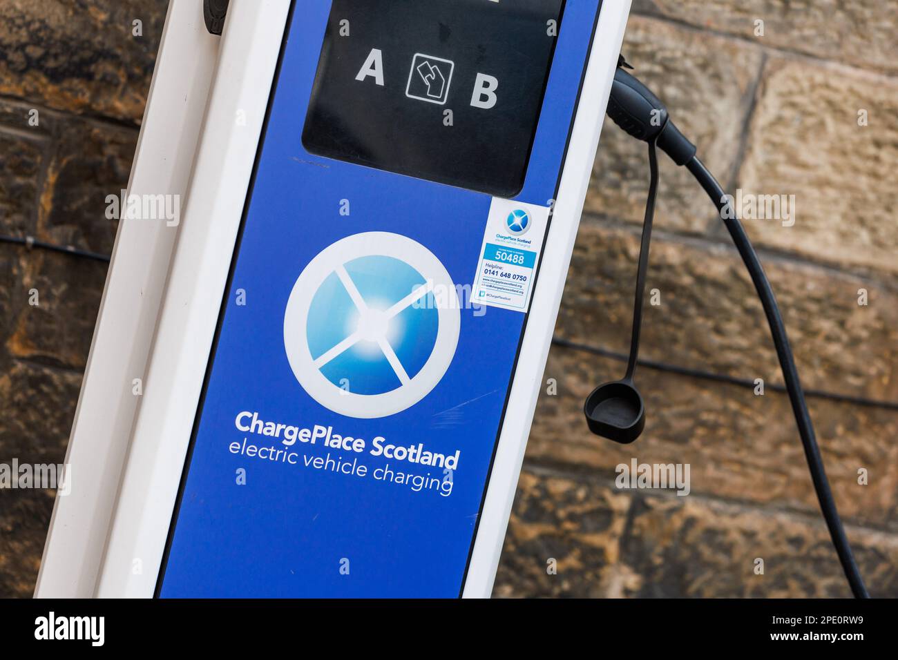 A red electric vehicle plugged in at a ChargePlace Scotland EV charging
