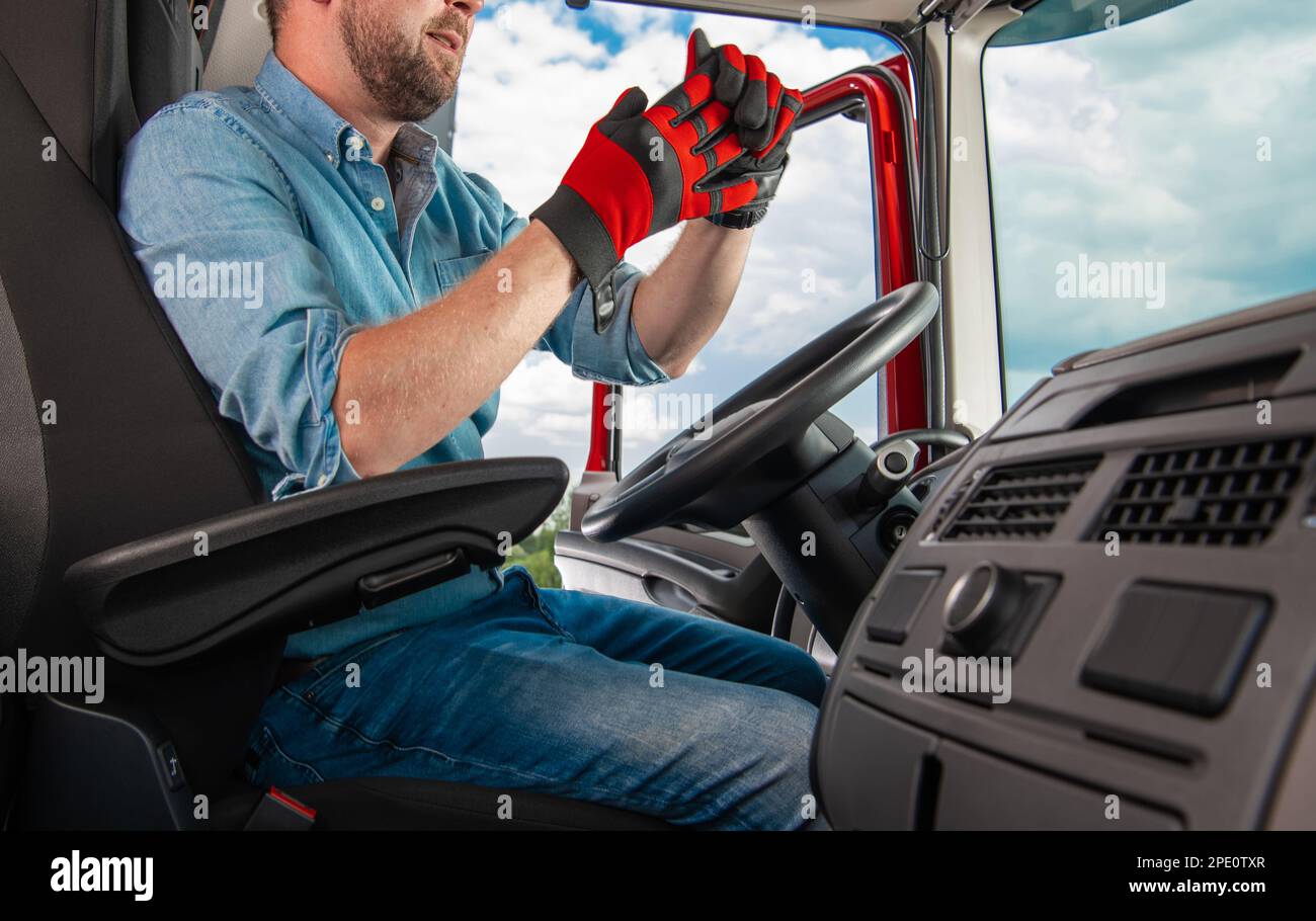Semi Truck Driver Wearing Gloves Behind the Wheel Getting Ready to Hook a Trailer. Stock Photo