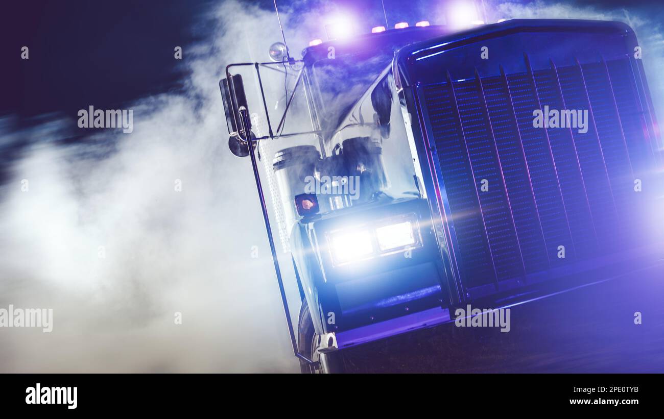 American Classic Semi Truck Drive Out of Smoke at Night. Truckers Theme. Stock Photo