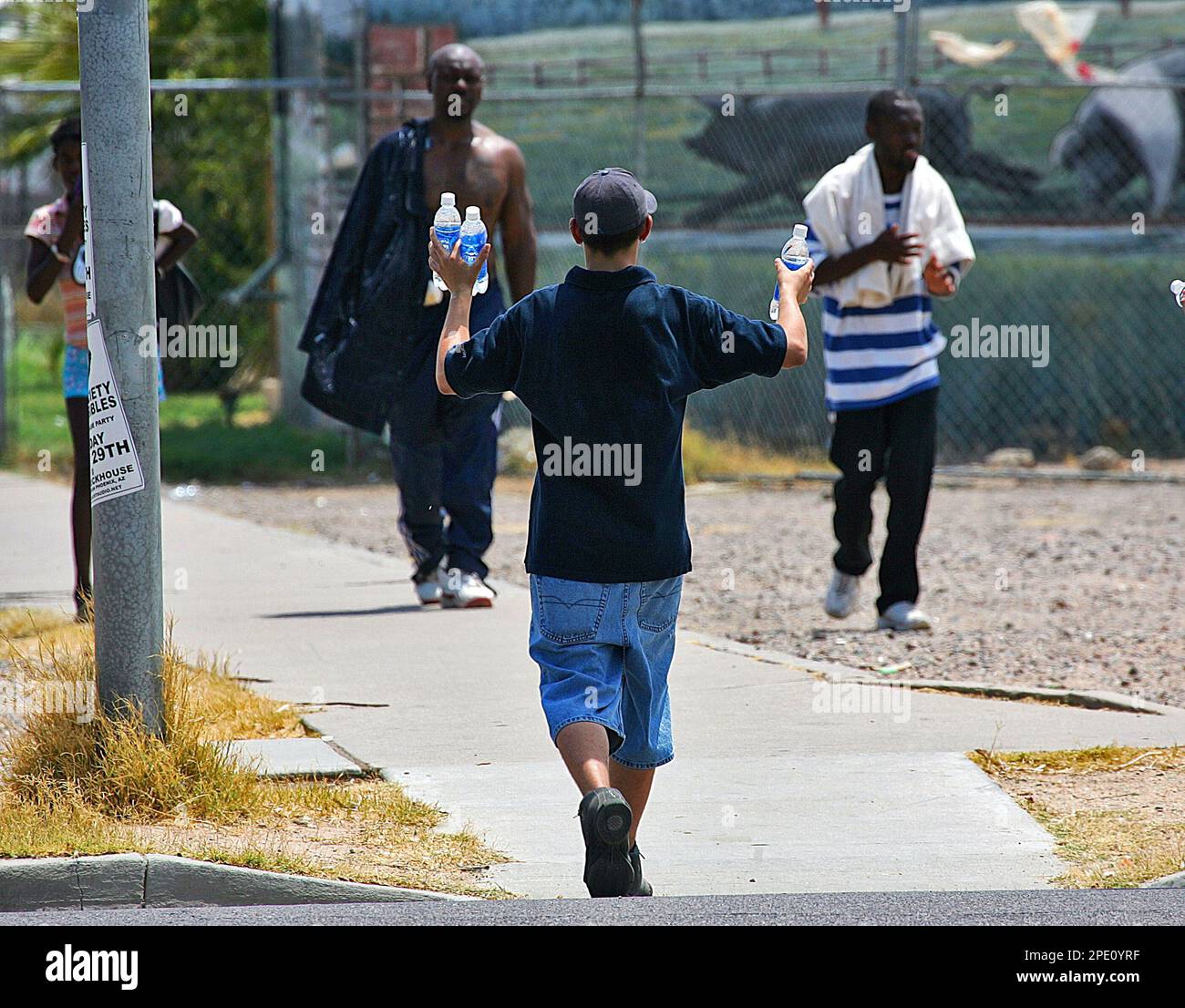 Salvation Army volunteer Bryant Vlk hands out bottled water to two people who had just walked