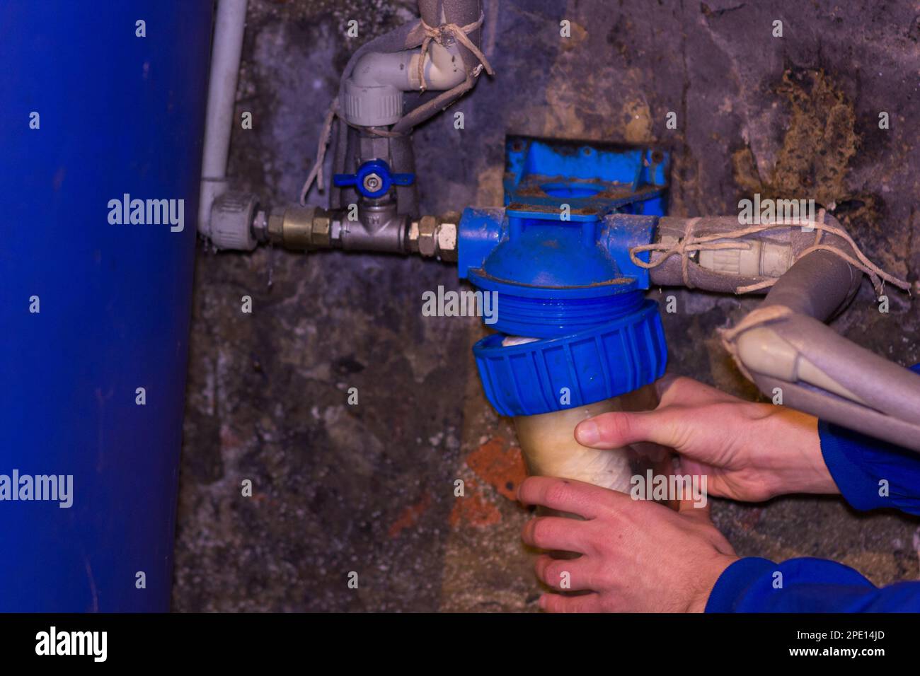 the plumber installs a water filter in the cellar located Stock Photo