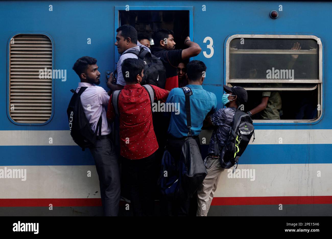 An overloaded train is seen as passengers travel at footboard at a main