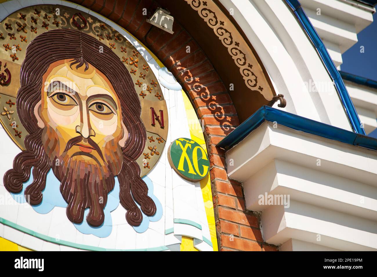 Khabarovsk, Russia - July 23, 2014: Contemporary Jesus Christ stone mosaic icon on an orthodox church. Sacred face on the wall colorful image close-up Stock Photo