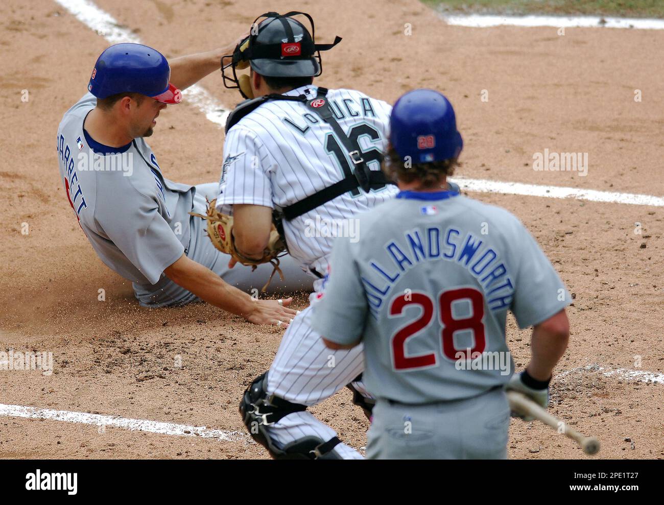 Florida Marlins catcher Paul Lo Duca (16) is late on tagging out Chicago  Cubs' Michael Barrett at home plate after Barrett and Todd Walker scored on  a double by Cubs Jeromy Burniz