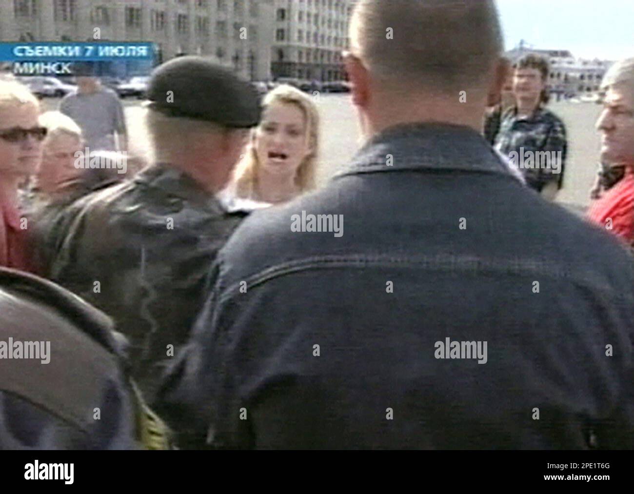 A Belarusian riot police officer argues with wife of disappeared