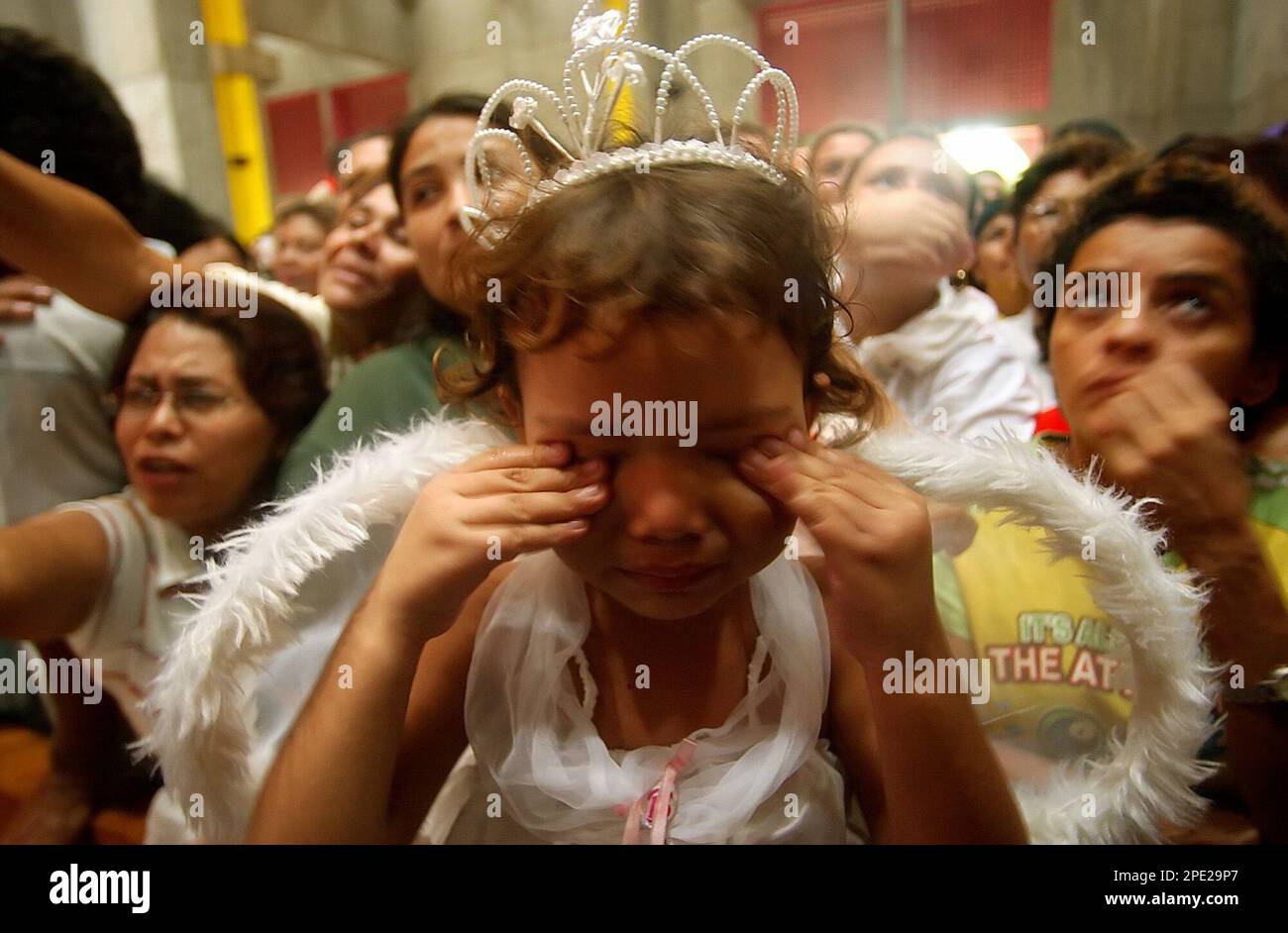 A girl dressed as an angel cries during the "Blood of Christ