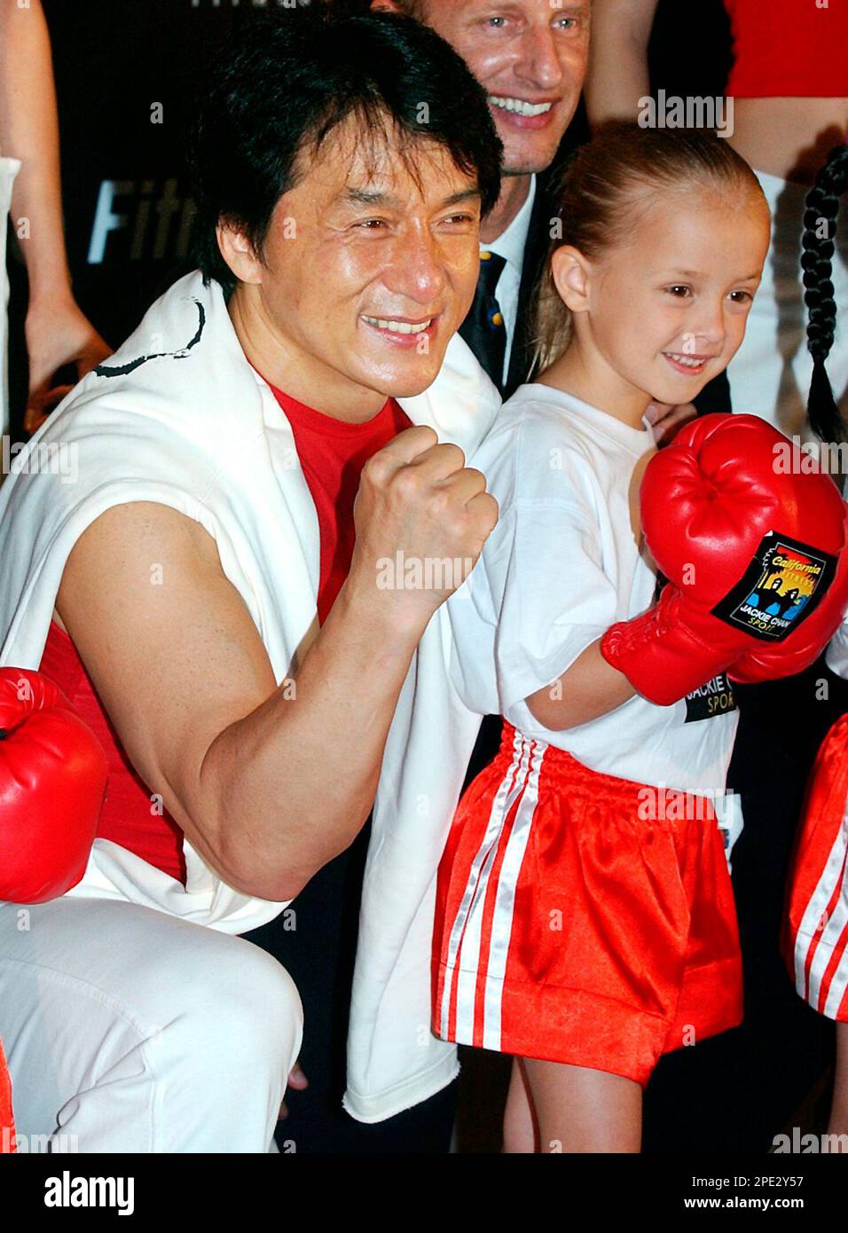 Action movie mega star Jackie Chan poses with a girl with boxer gloves
