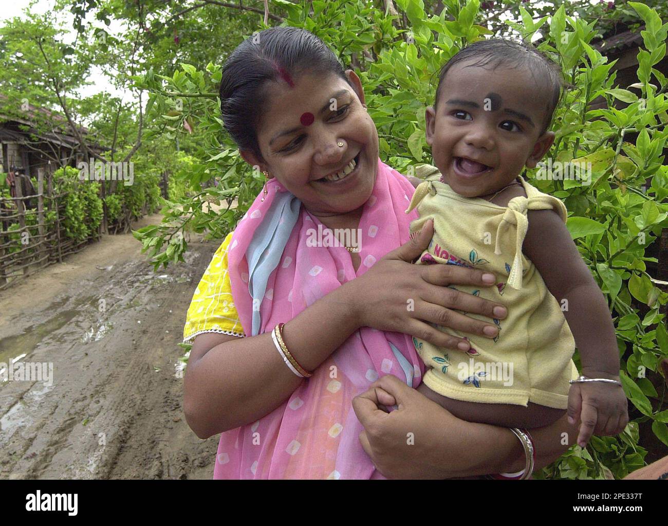 Namita Roy holds her son Tsunami Roy outside their house in Hut