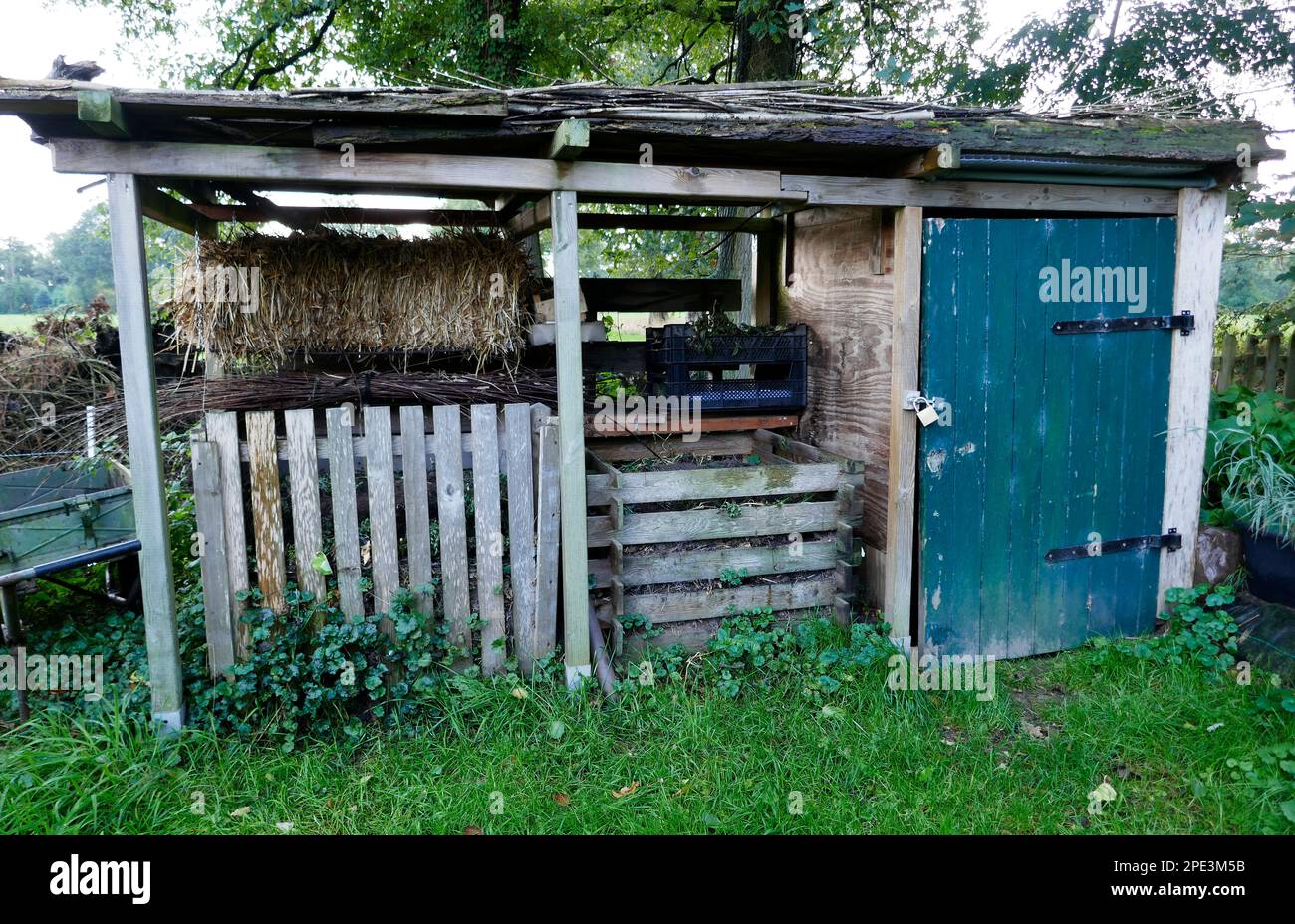 A simple garden shed with two compost containers and a closed section