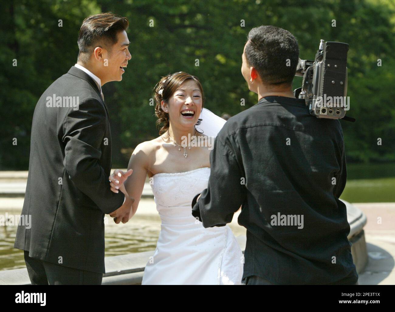 Video production company owner Kim Wang, right, who photographs and videotapes weddings, shares a laugh with Hong Kong-born Donna Lau, center, and her fiance Eric Luk, left, Thursday, June 9, 2005, at pic