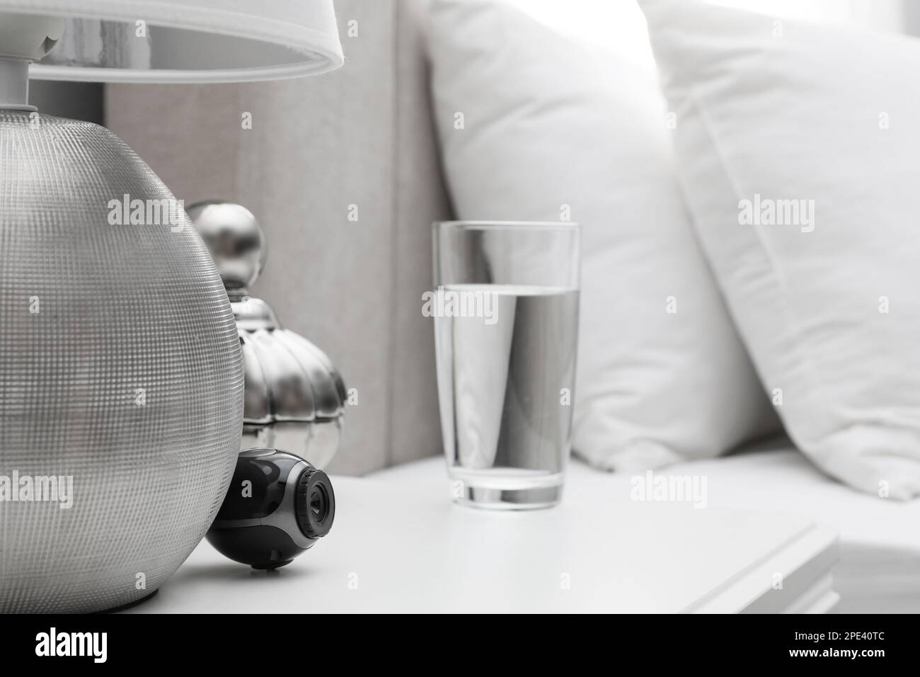 Small hidden camera on white nightstand in bedroom Stock Photo