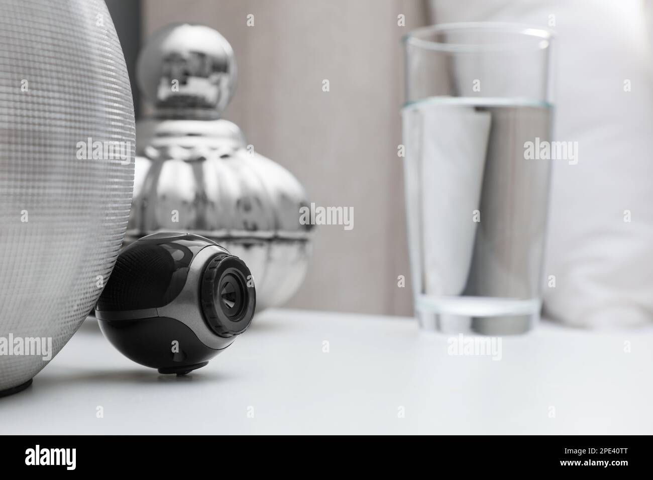 Small hidden camera on white nightstand in bedroom Stock Photo