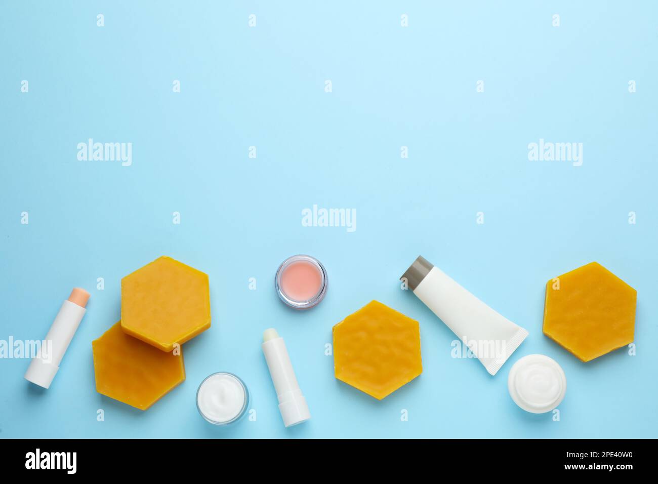 Flat lay composition with beeswax and cosmetic products on light blue ...