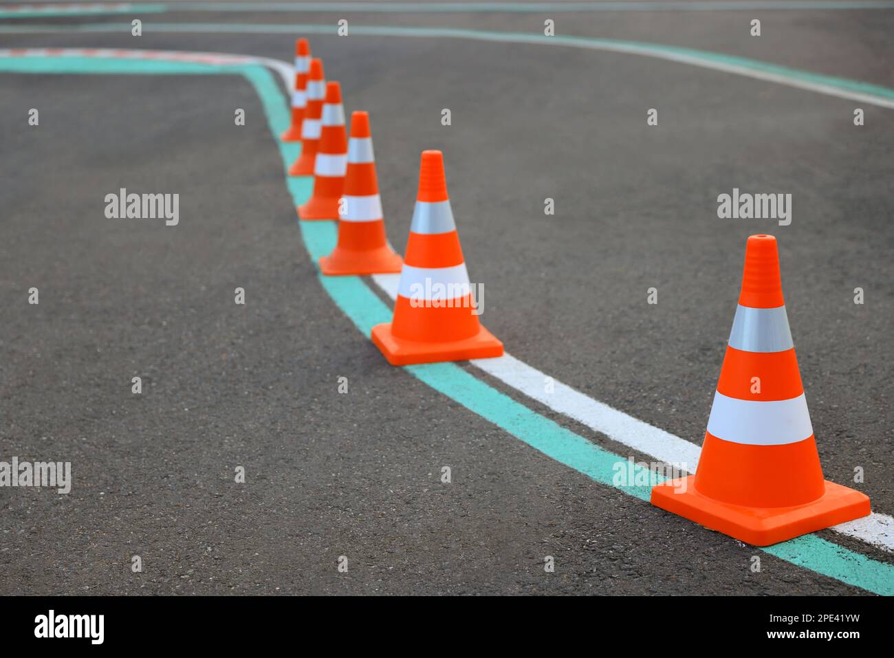 Driving school test track with marking lines, focus on traffic cone