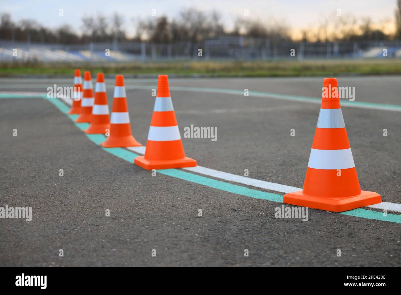 Driving school test track with marking lines, focus on traffic cone