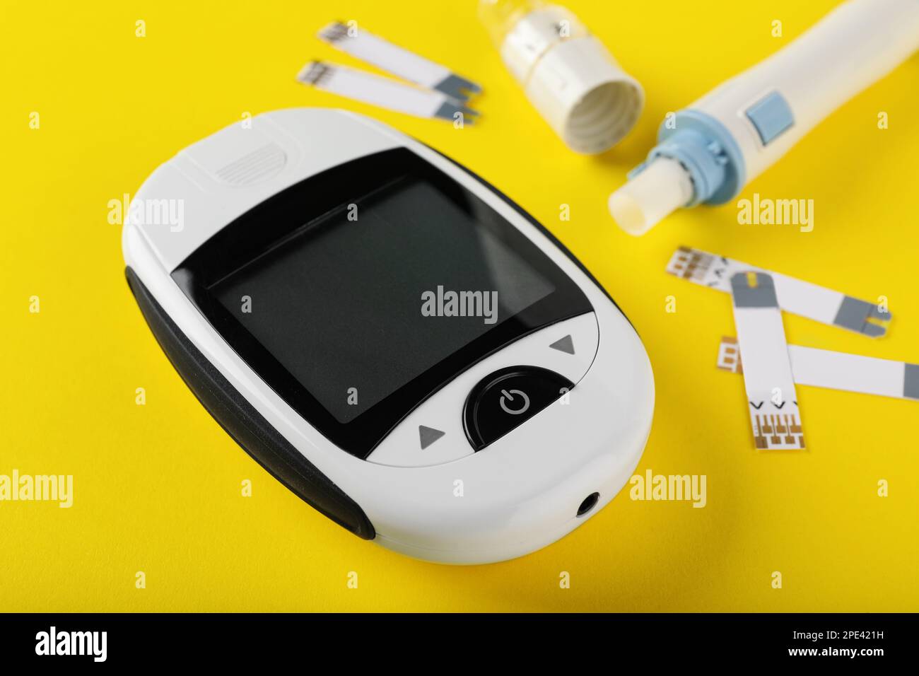 Digital lancet pen and test strips on yellow background