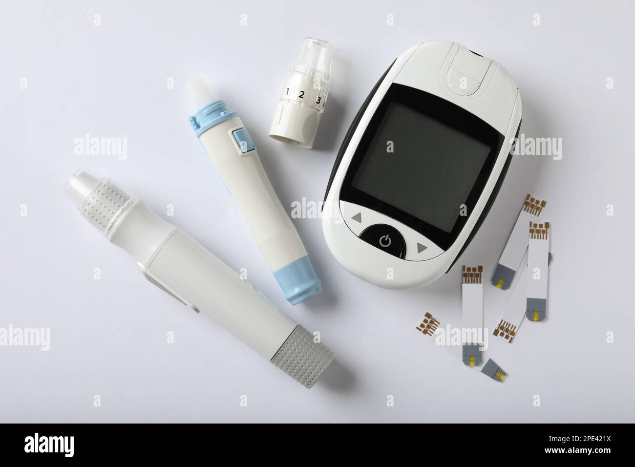 Digital lancet pens and test strips on white background, flat lay. Diabetes control