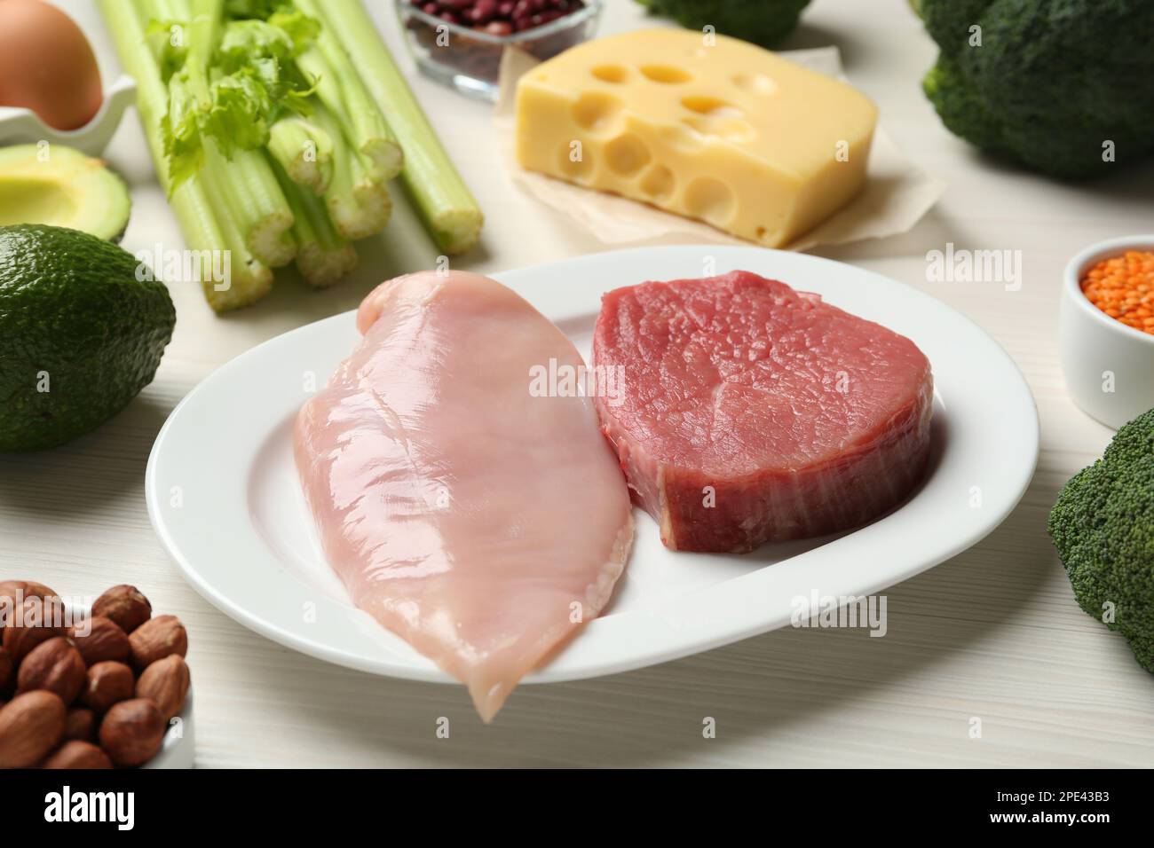 Fresh meat and other products on white wooden table. Sources of