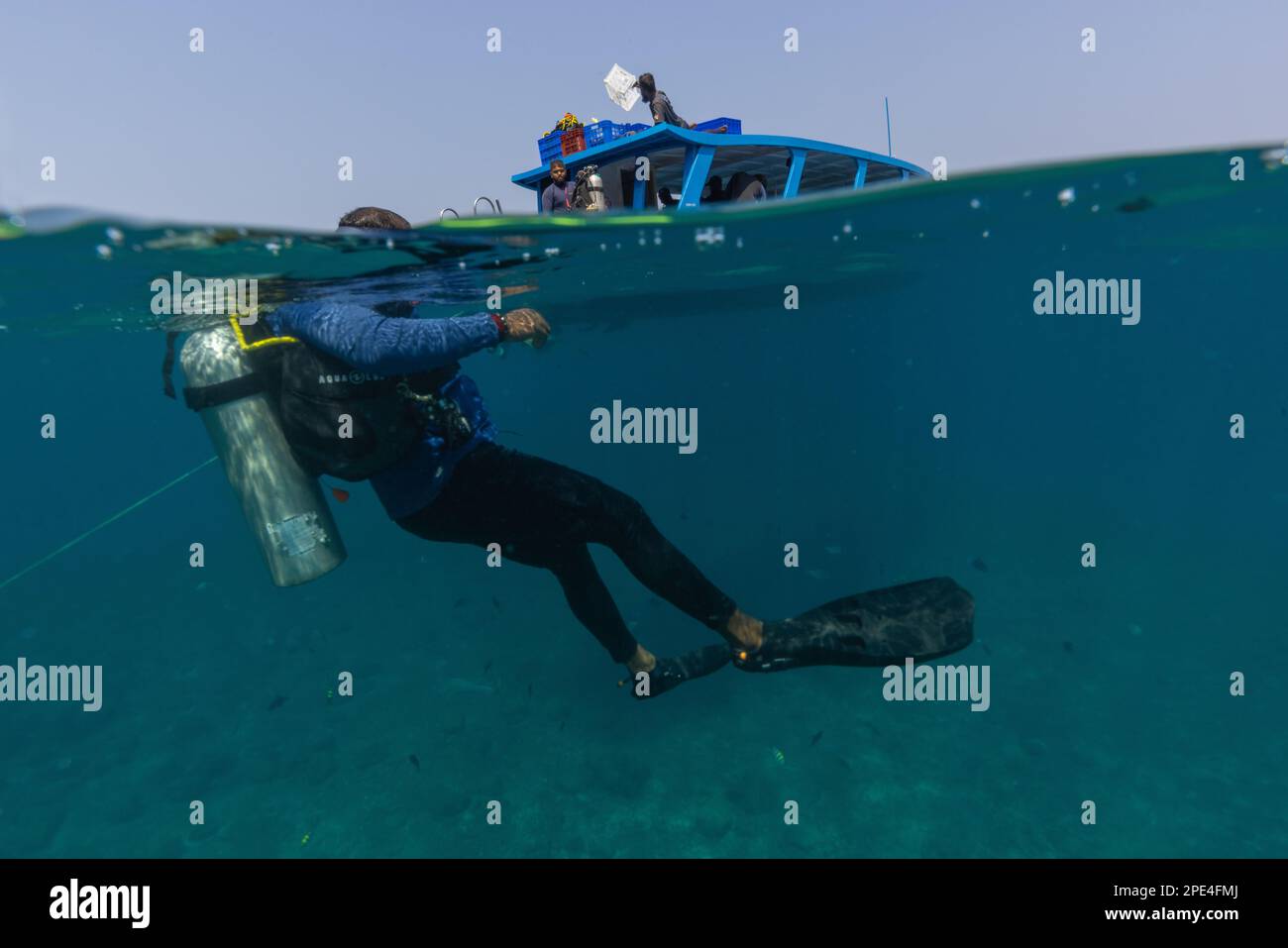 A Scuba Diver is about to descend underwater after jumping off from the boat (photographed in Netrani Island - Karnataka India) Stock Photo