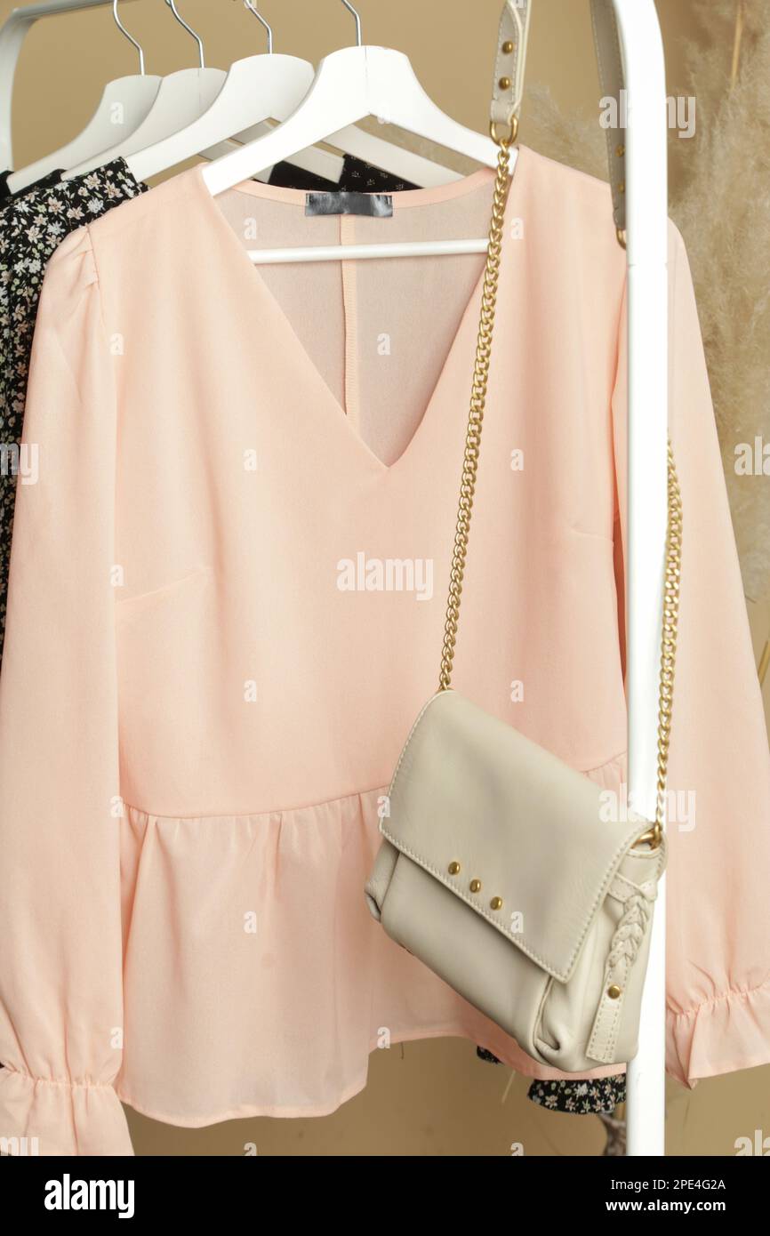 Women's Clothes. Clothes rack with stylish and elegant satin long sleeved blouses in fashion atelier. Minimalist fashion blog concept. Stock Photo