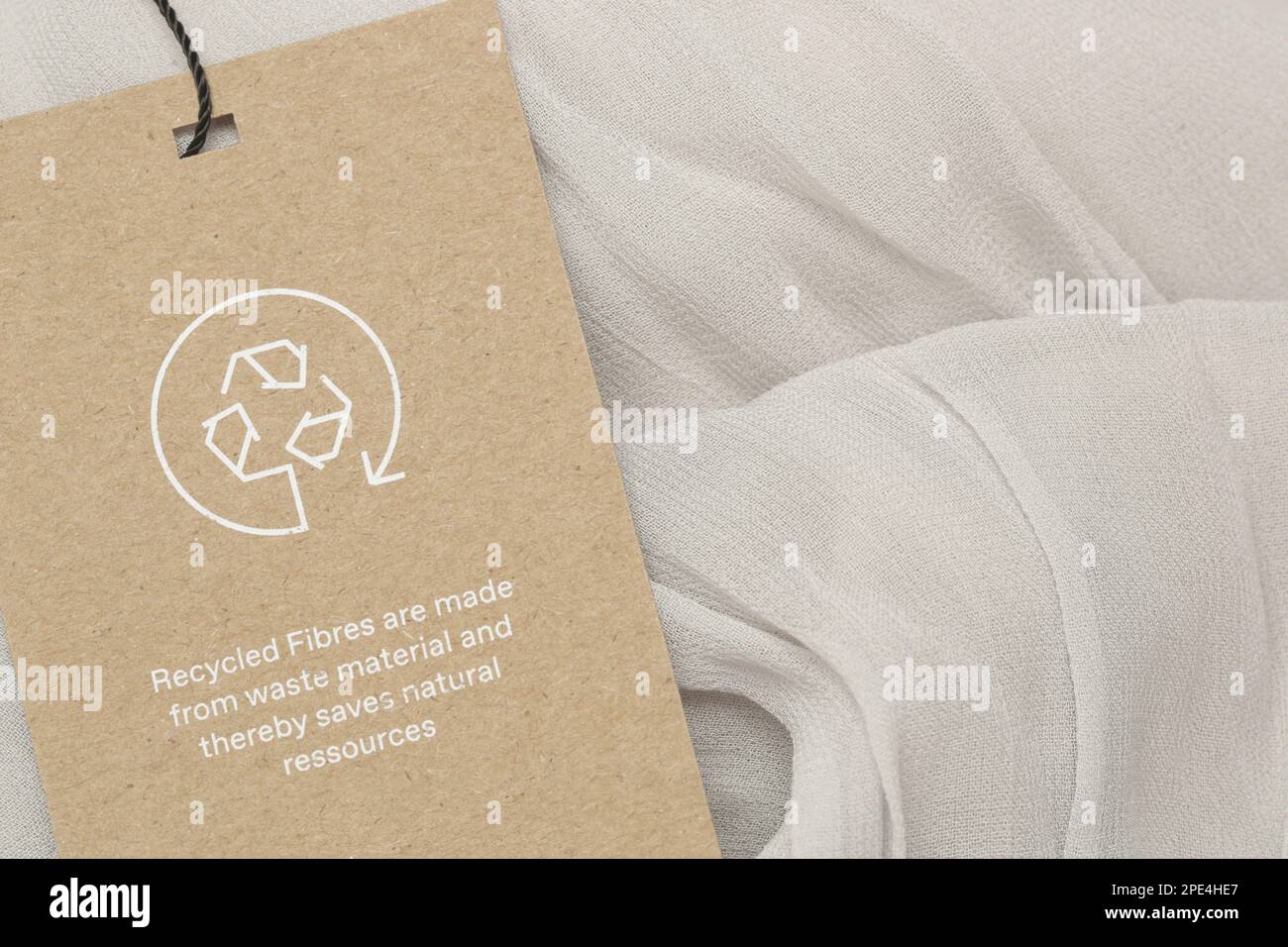 Close up of clothing tag with recycle icon. Recycling products concept