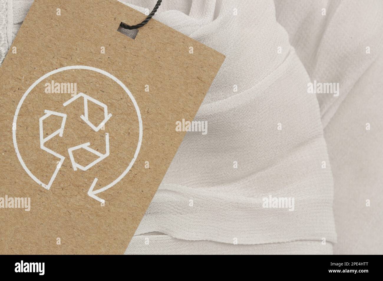 Close up of clothing tag with recycle icon. Recycling products concept