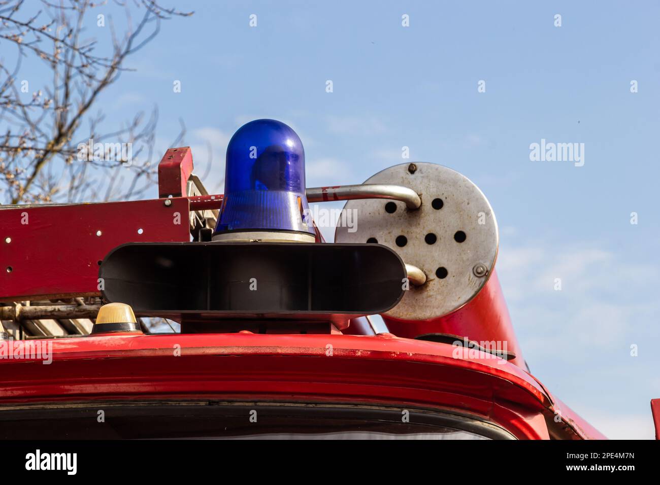 Close-up view of a blue light and fire hose on the roof of an antique fire engine. Stock Photo