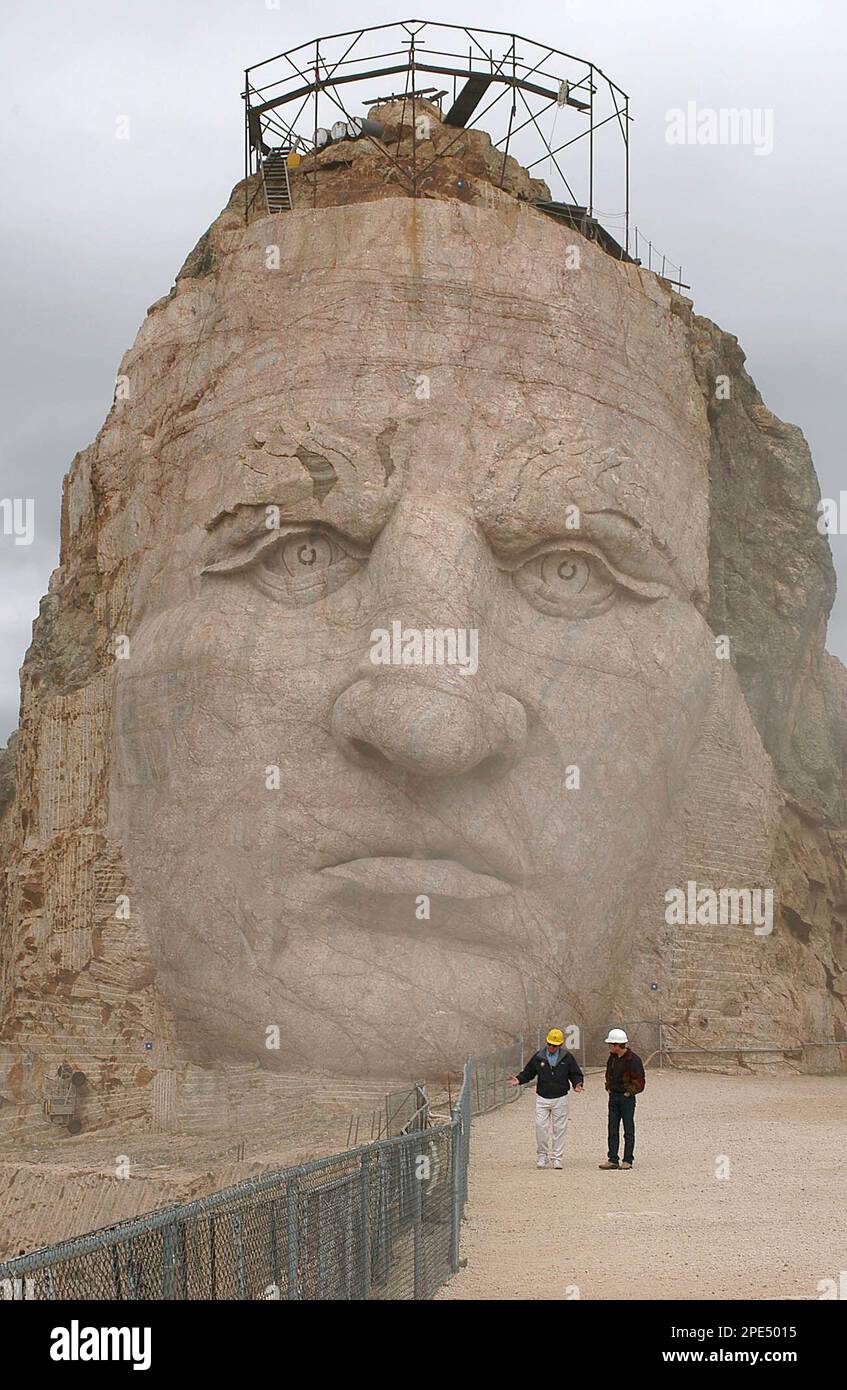 Crazy Horse employees walk in front of the face as dust rises up from  workers below Tuesday, May 24, 2005, at the Crazy Horse Memorial near  Custer, S.D. While a dedicated family