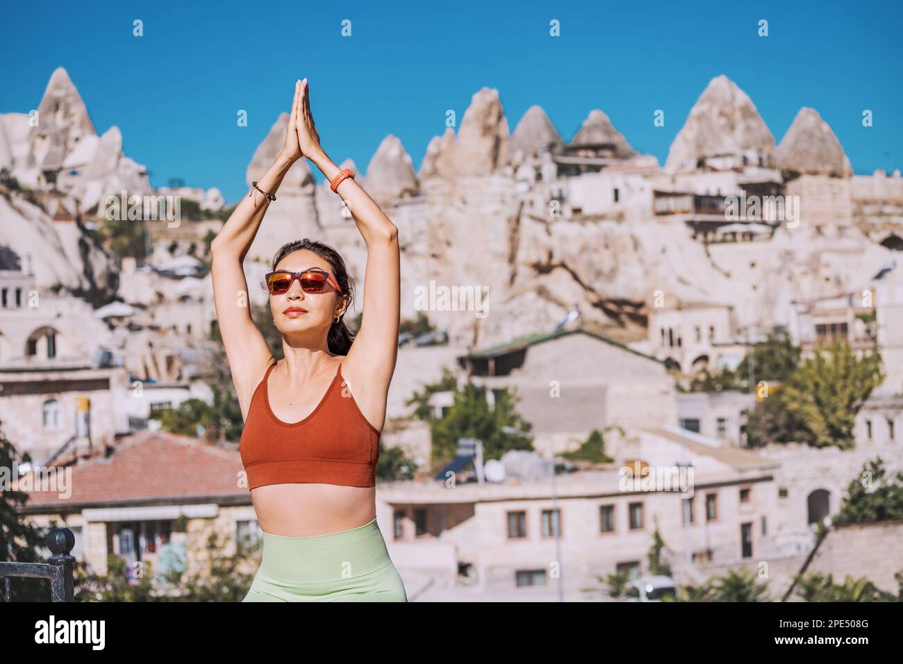 a girl does yoga exercises and meditation on the roof of a hotel in Cappadocia - famous for its flying balloons and unique energy Stock Photo