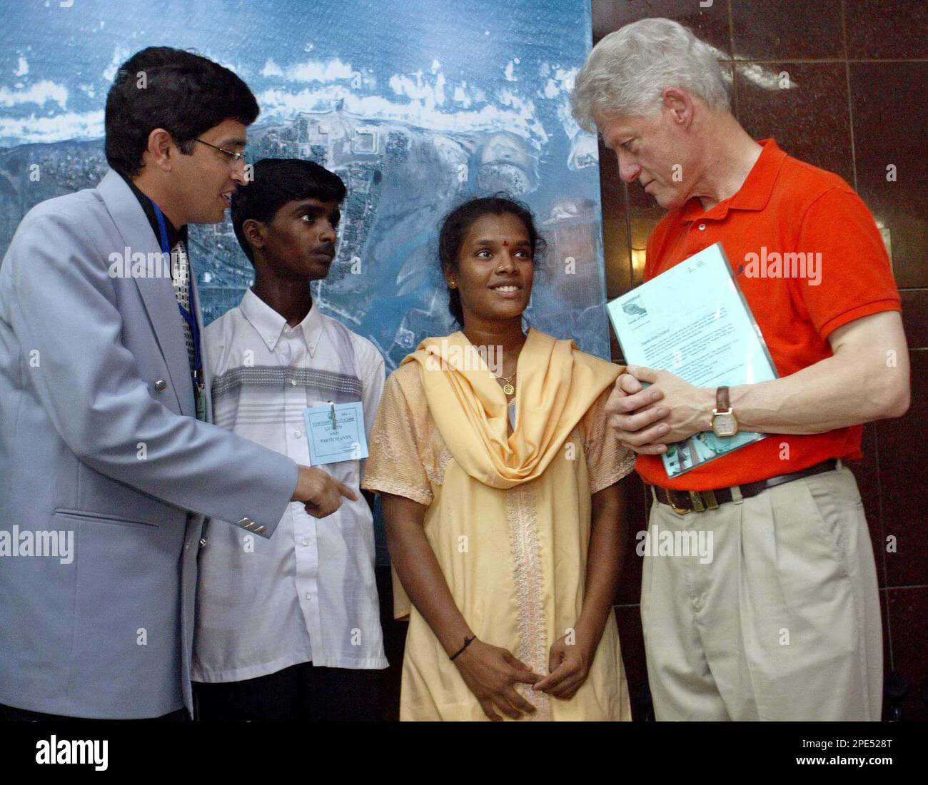 Former U.S. President Bill Clinton, right, talks to K. Nirmala, 15, second  right, as Kumar Vati, second left, and J. Radhakrishnan, the top revenue  official of Nagappattinam district look on, in Nagappattinam,, image size:1300x1100