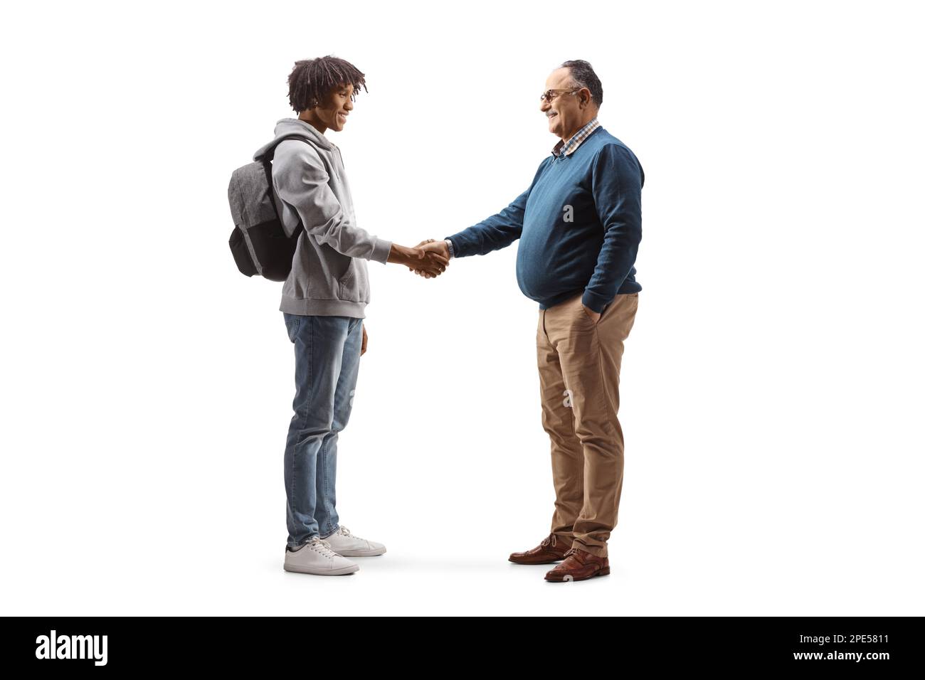 Full length profile shot of an african american male student and a mature man shaking hands isolated on white background Stock Photo