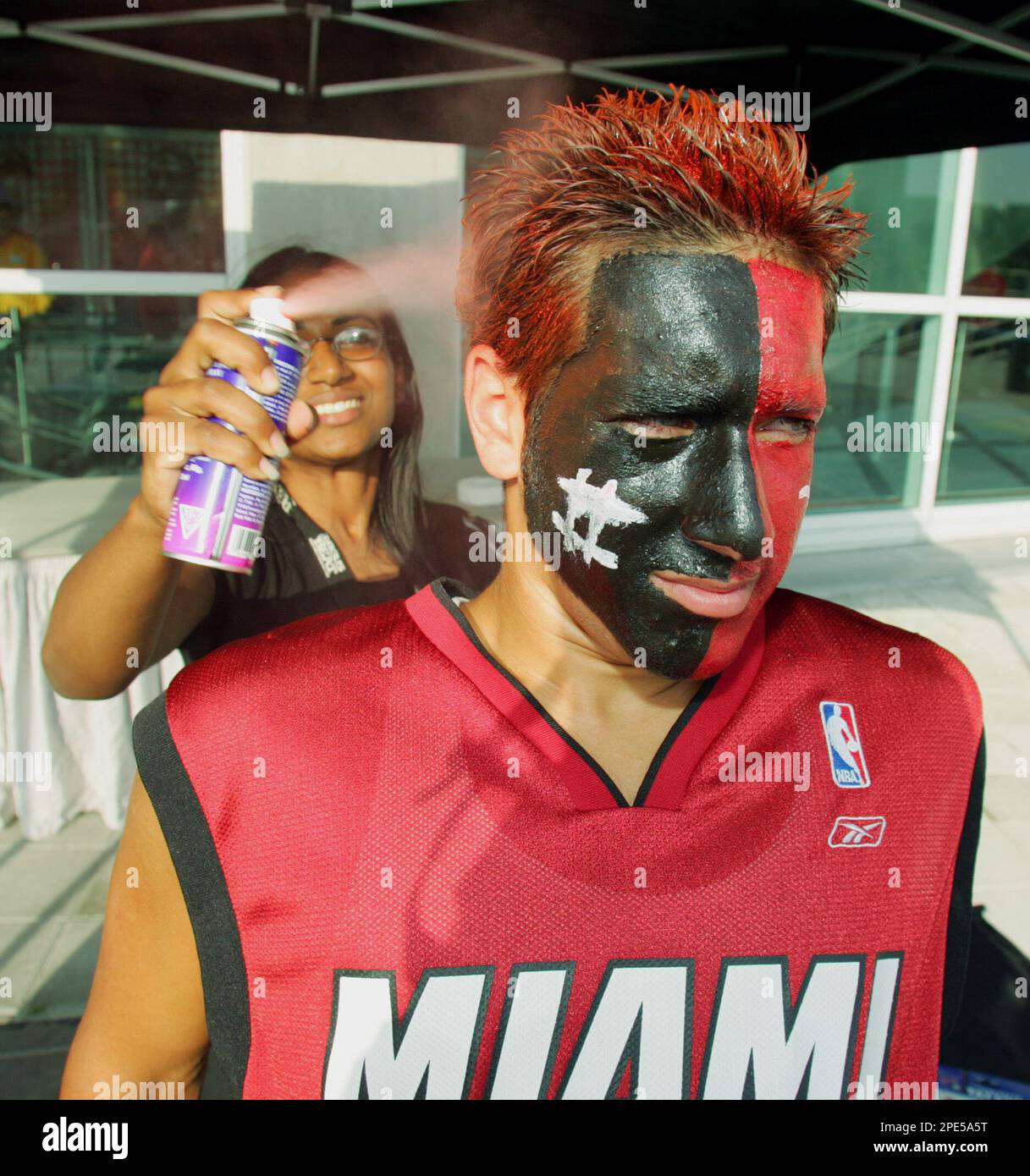 Miami Heat fan Virgil Rodriguez gets the finishing touch on his hair by