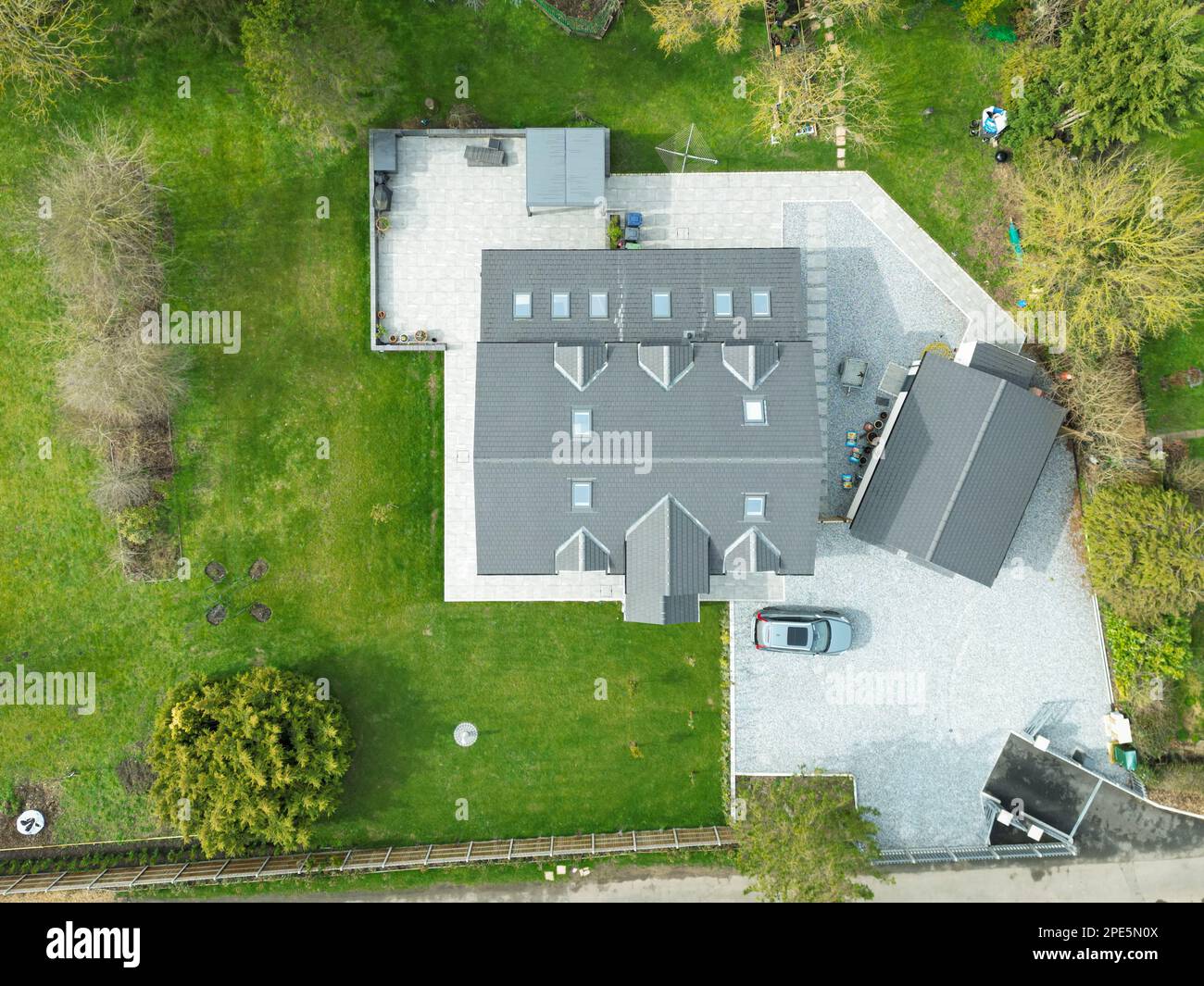 Aerial view of a large, recently built house which was built onto a previous bungalow. Showing detail of the light blue gravel. Stock Photo
