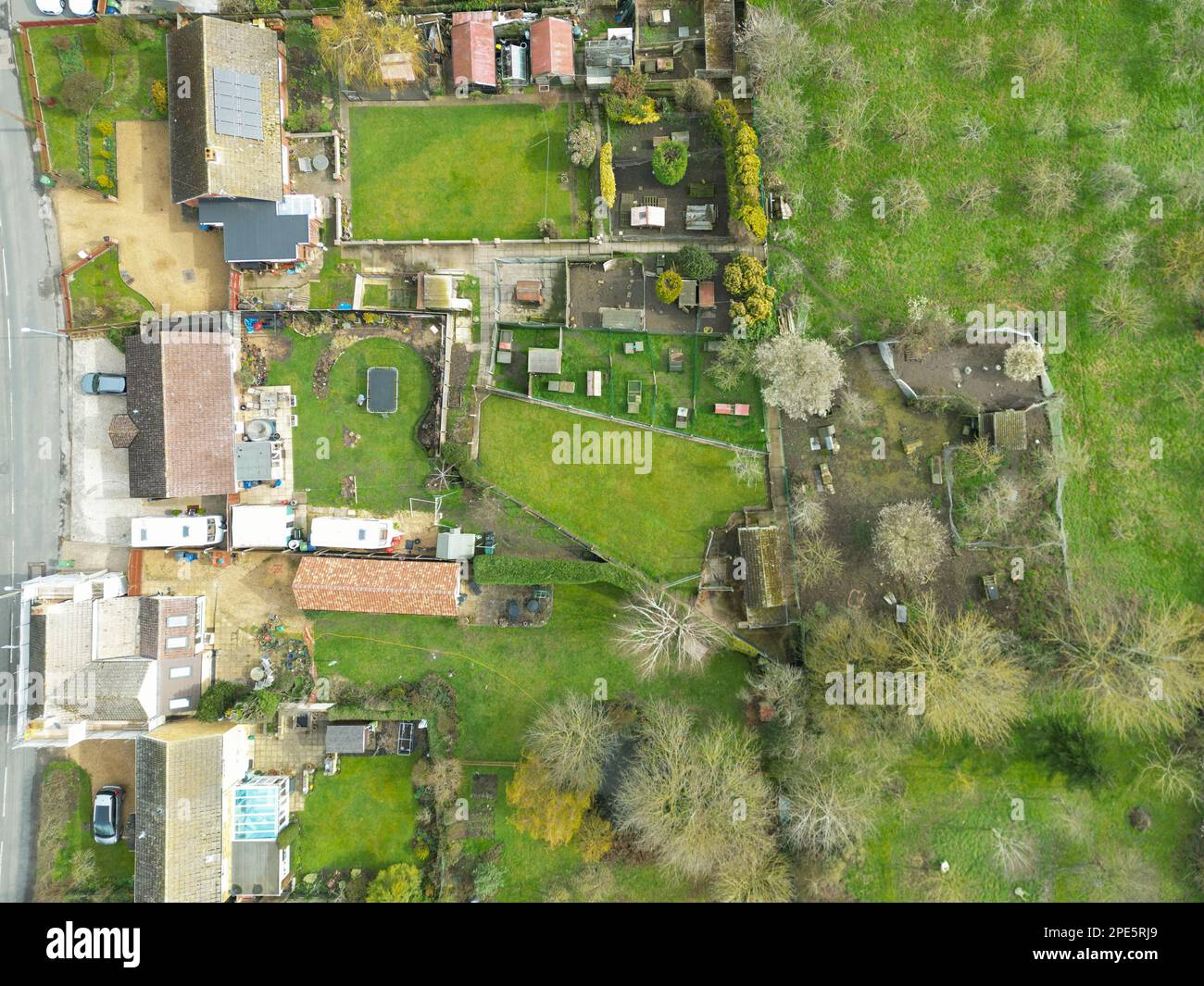 Top down view of a mixture of old and modern houses and bungalows seen at the edge of an East Anglian village. Note the orchard on the far right. Stock Photo