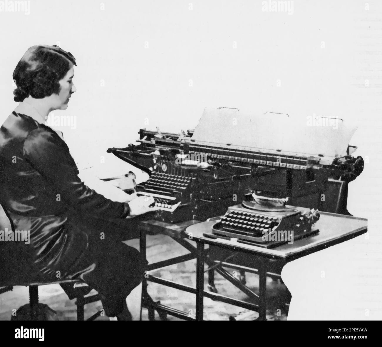 A woman using a tabulating machine, c1933. The tabulating machine was an electromechanical machine designed to assist in summarising information stored on punched cards. Invented by Herman Hollerith (1860-1929), the machine was developed to help process data for the 1890 U.S. Census. Later models were widely used for business applications such as accounting and inventory control. Stock Photo