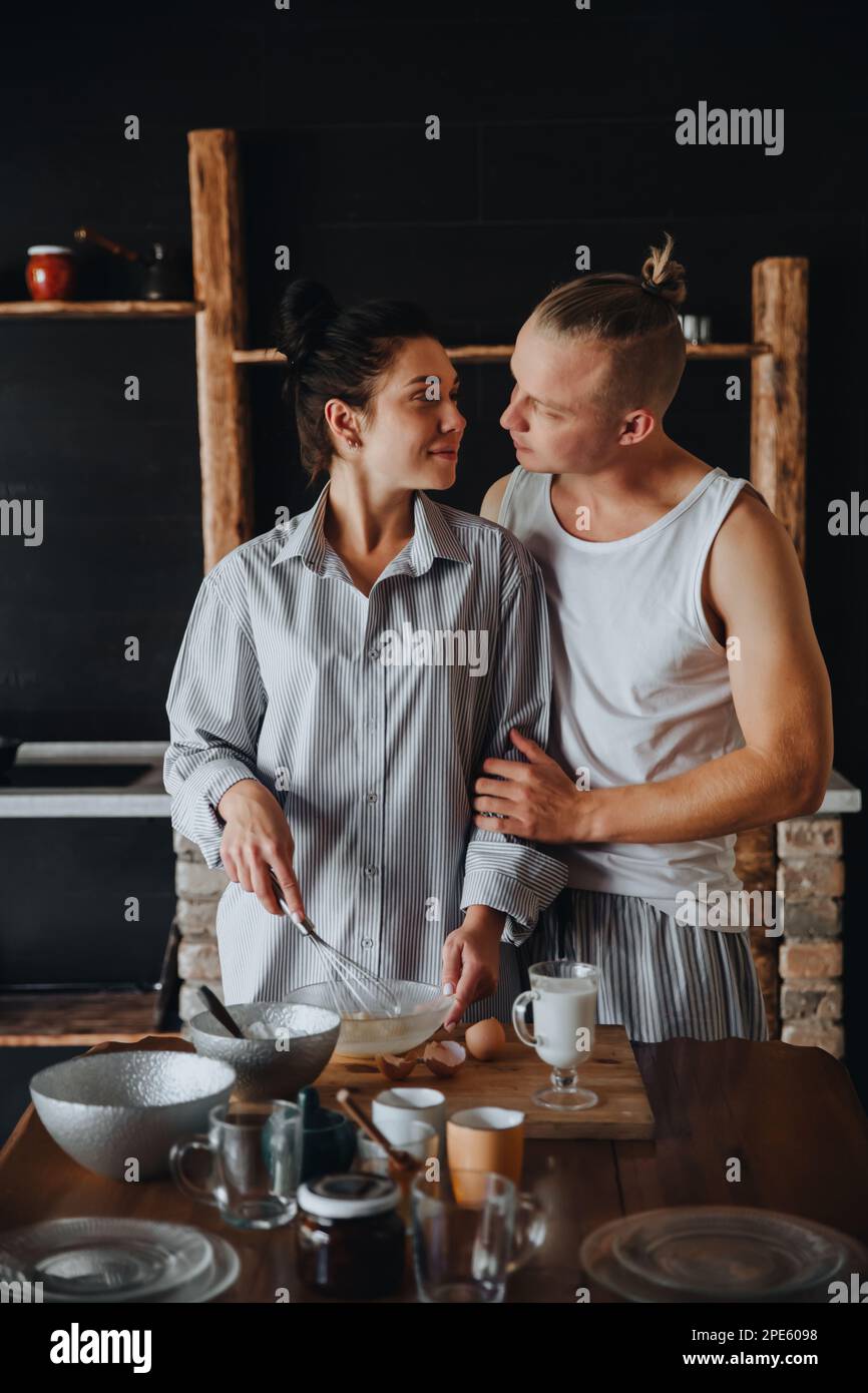 Young couple in love cook healthy food in the kitchen together. While laughing and talking. Stock Photo