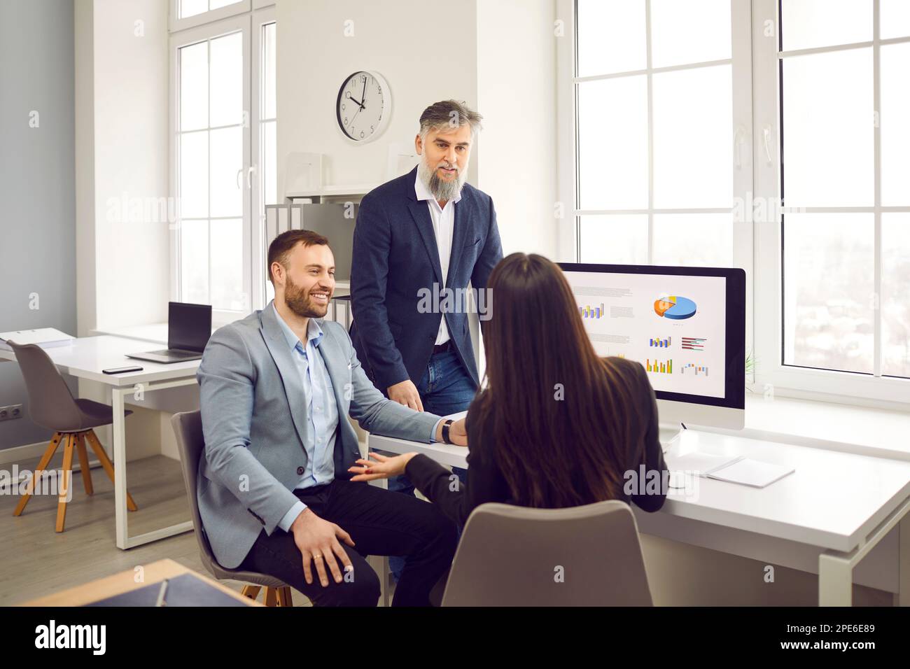 Business team having a work meeting, discussing their strategy, and using a computer Stock Photo