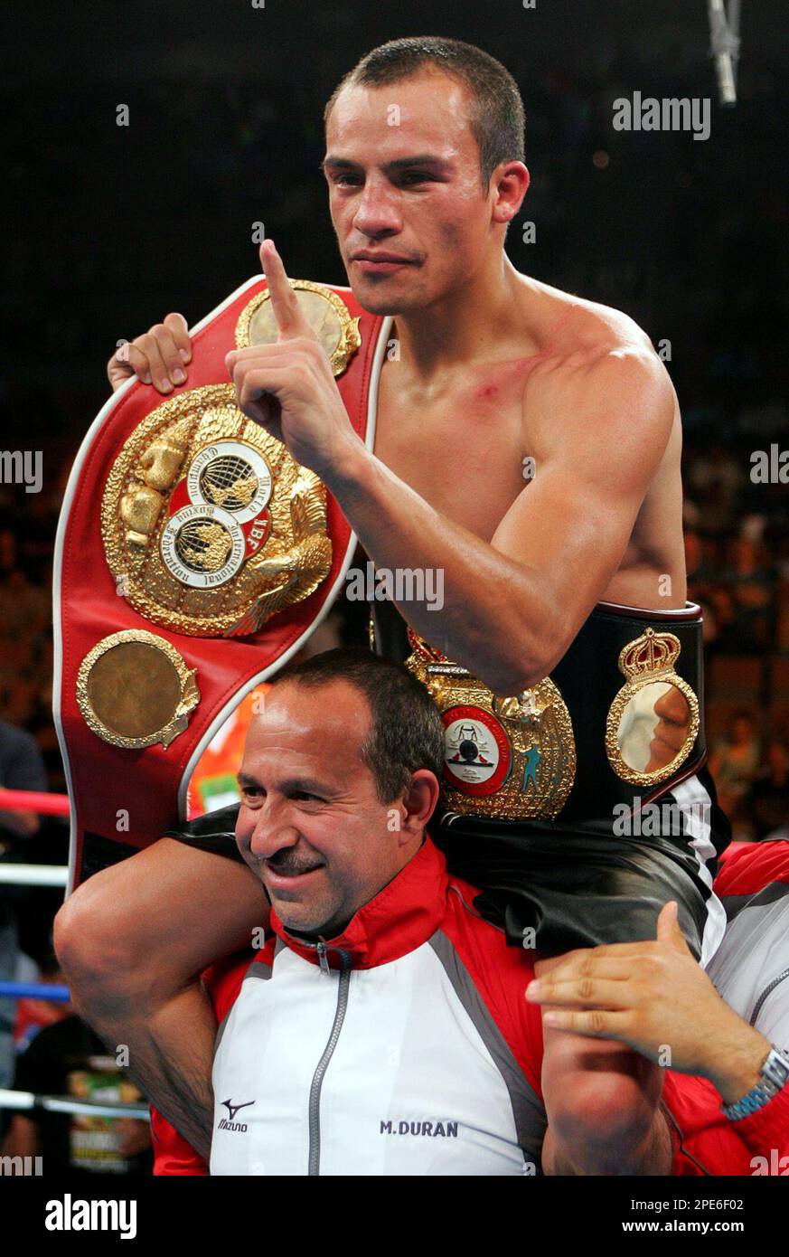 Juan Manuel Marquez, of Mexico, on the shoulders of his cornerman, Jaime  Quintana, displays his WBA/IBF featherweight after defeating Victor Polo,  of Colombia, in their championship bout on Saturday, May 7, 2005,, image size:873x1390