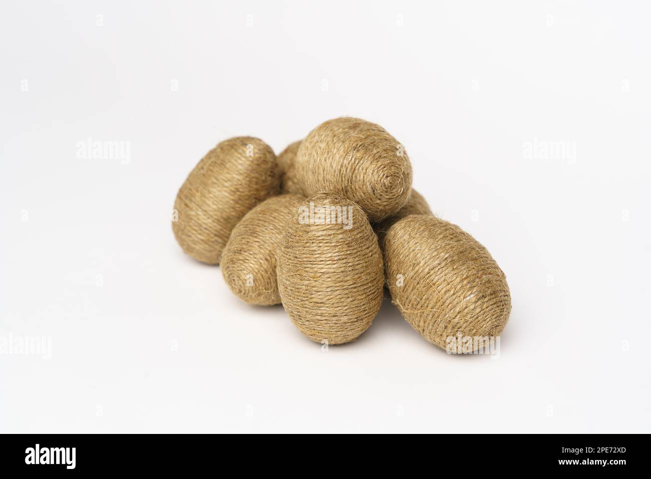 Hand wrapped easter eggs with jute twine, isolated white background. Studio Stock Photo