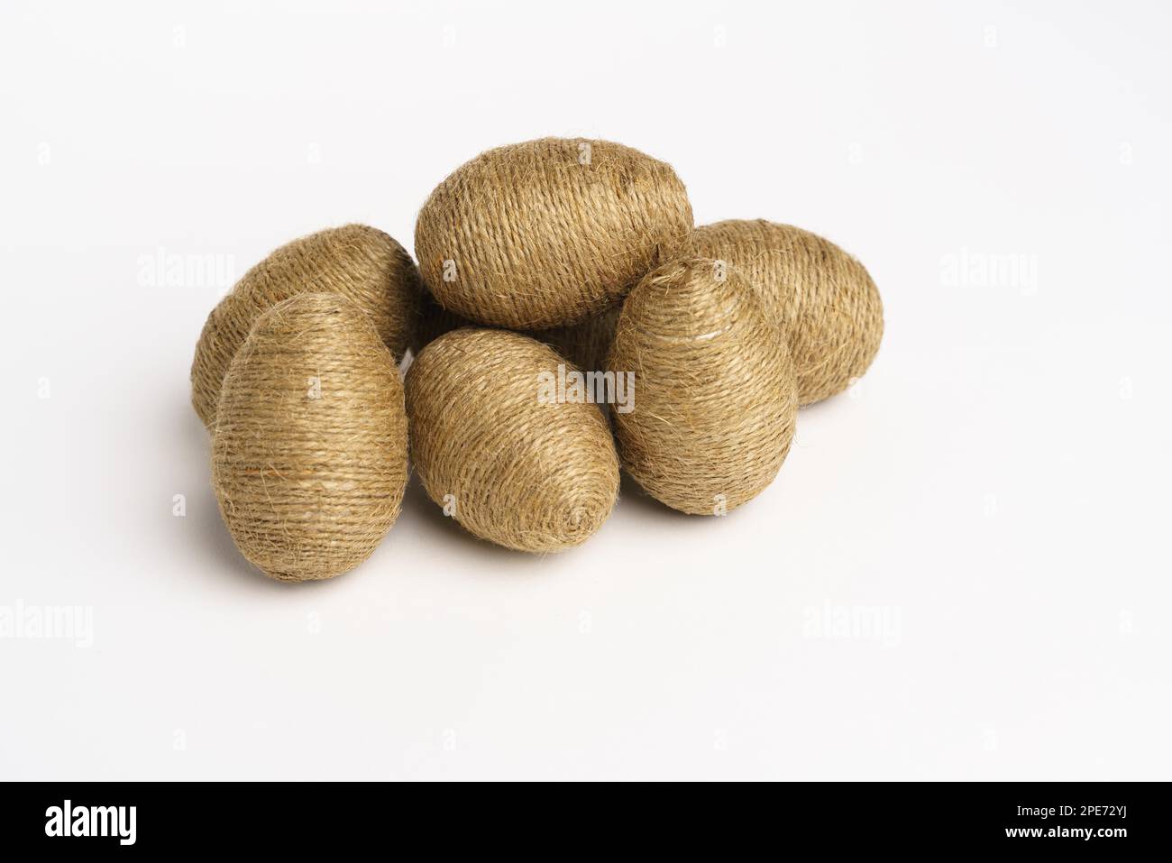 Hand wrapped easter eggs with jute twine, isolated white background. Studio Stock Photo