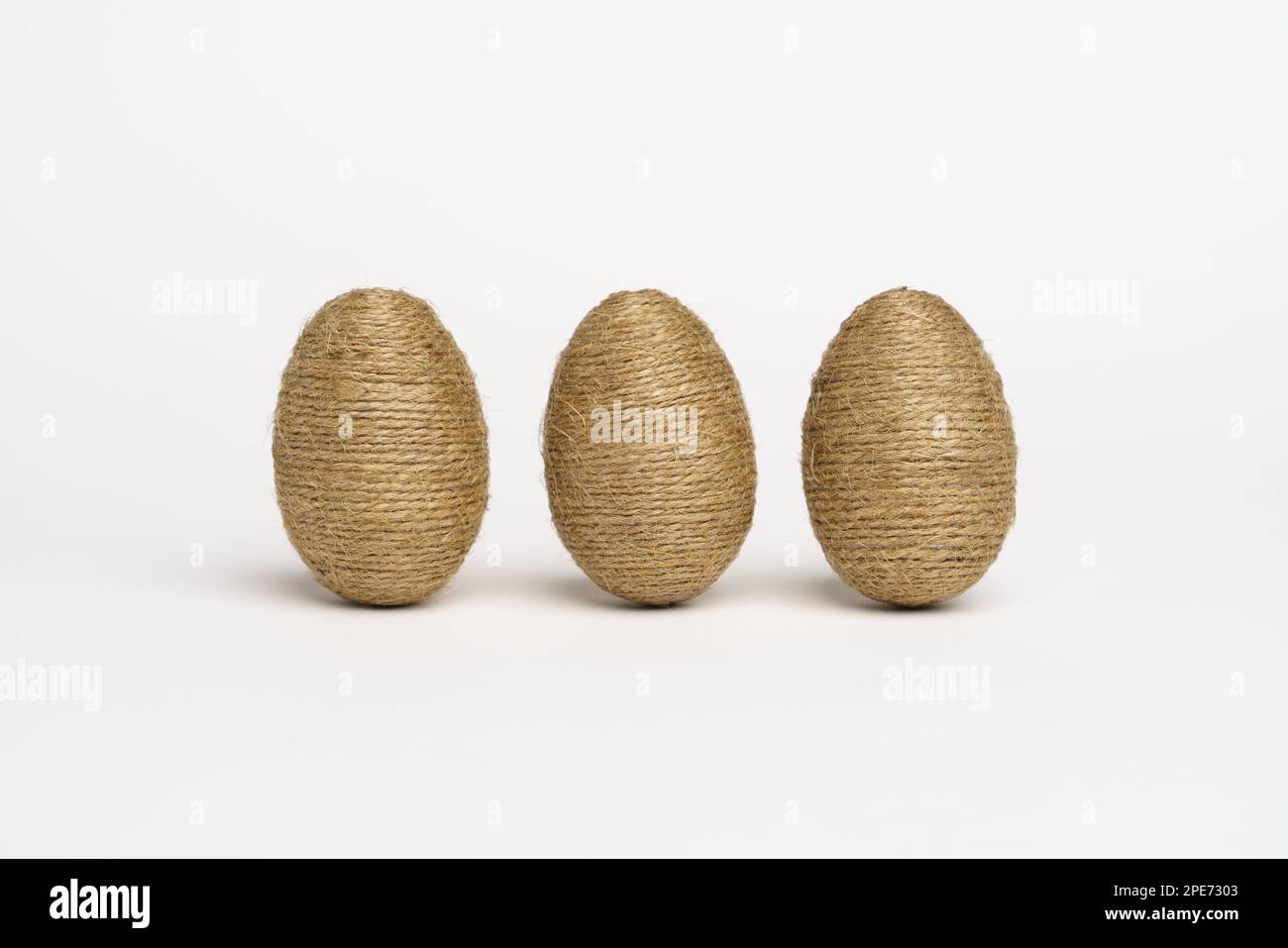 Hand wrapped easter eggs with jute twine, isolated white background