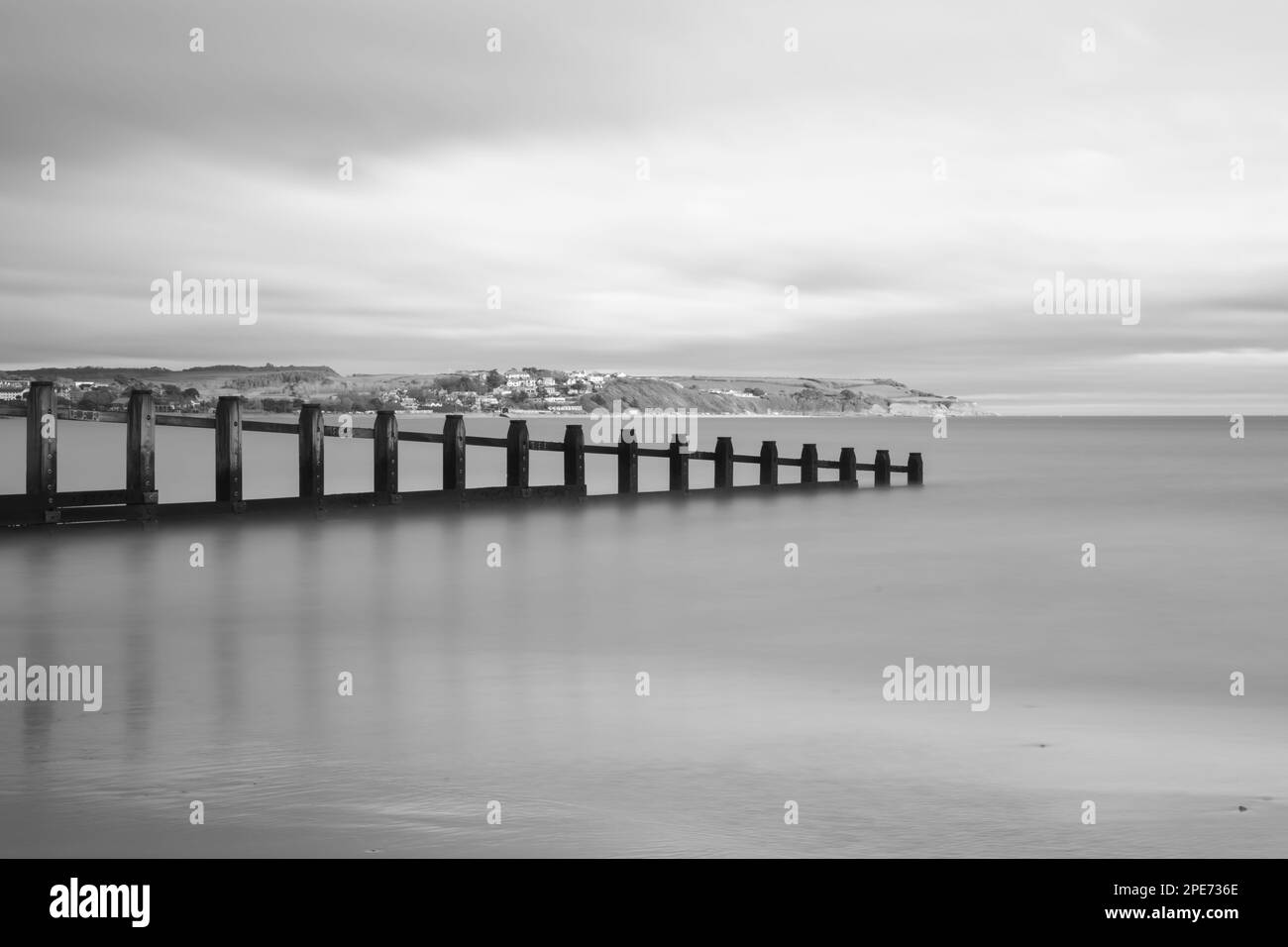 Landscape photo of a groyne in the sea at Dawlish Warren nature reserve with Exmouth in the background Stock Photo