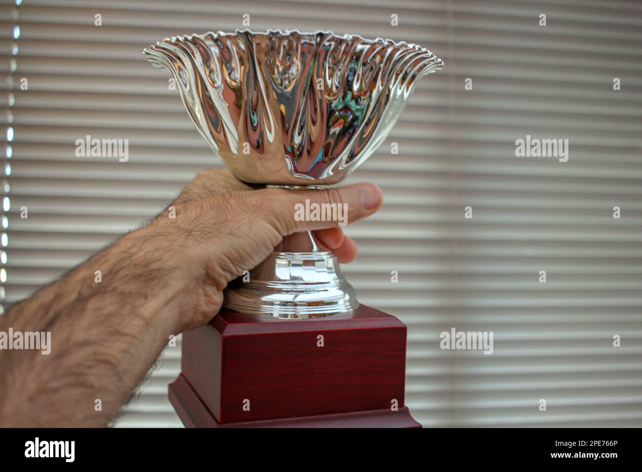 the winner has got a trophy in his hand Stock Photo