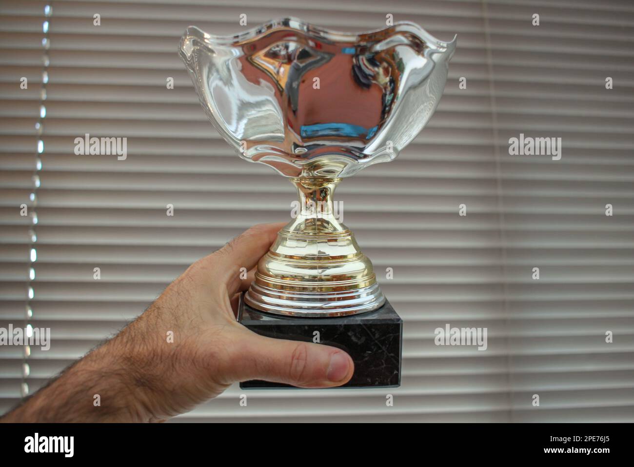 the prize of the winner is a trophy that holds in his hand Stock Photo