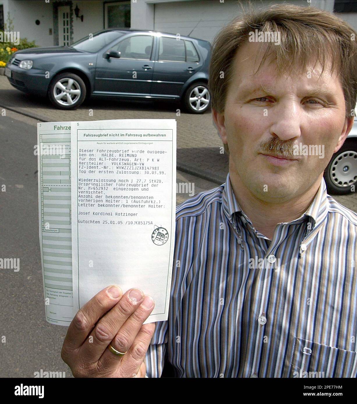 Reimund Halbe zeigt die Papiere des VW Golf, Hintergrund, der zuvor ...