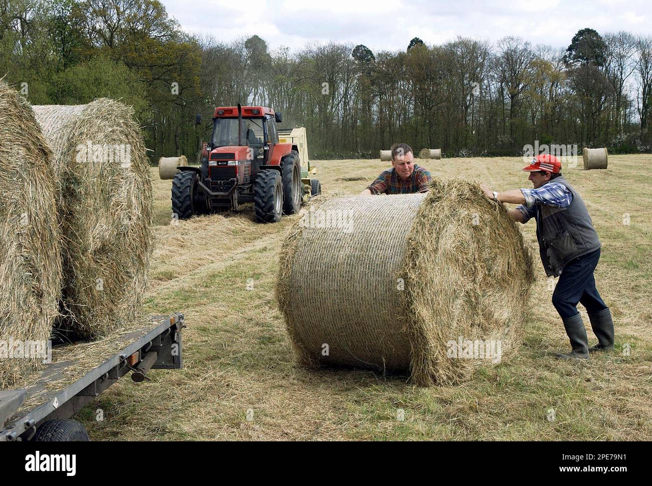 Farmers baling and loading round bales of hay, Holmes Chapel, Cheshire