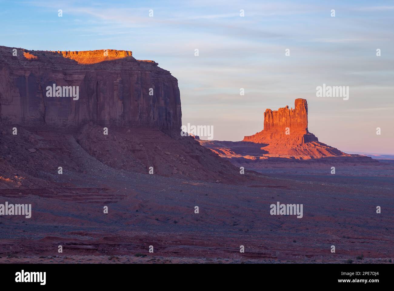A picture of the Monument Valley landscape at sunset, with the Big Indian Butte rock formation on the right. Stock Photo