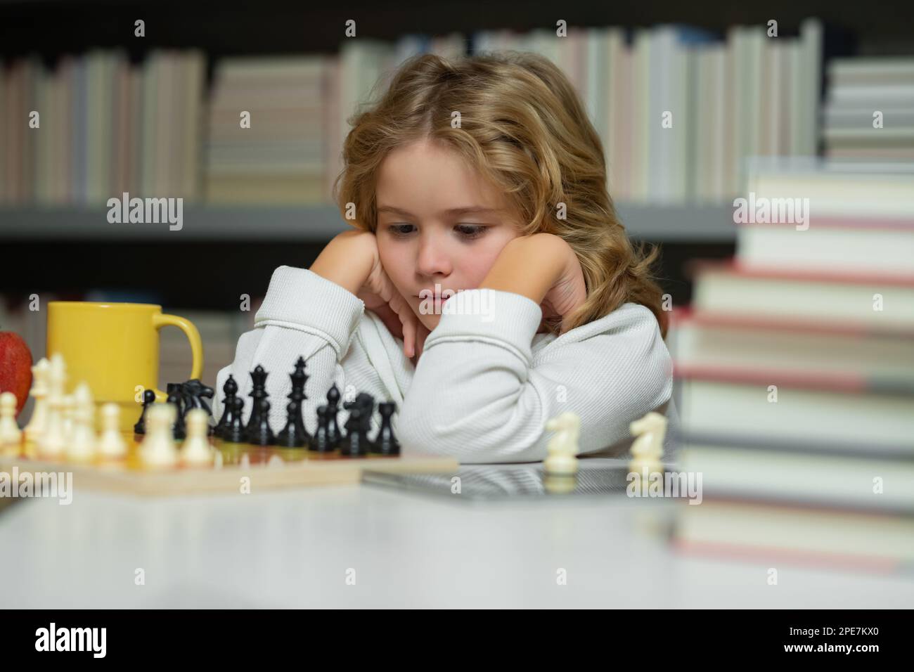 Early development. Boy thinking about chess. The concept of learning and growing children. Chess, success and winning Stock Photo