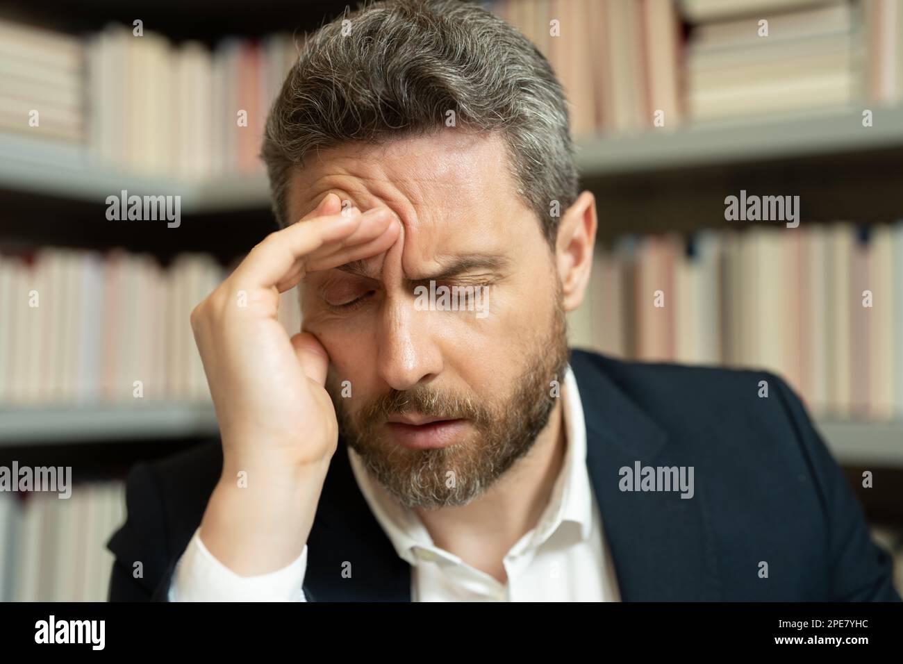 Tired, headache and eye strain on laptop. Man with stress, burnout and fatigue eyestrain. Business man rubbing tired eyes after computer work. Vision Stock Photo