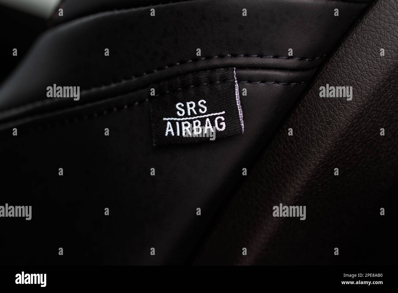 Close up view of airbag label on the side of a car seat. Airbag safety system symbol on the car seat. Modern car interior details. Stock Photo